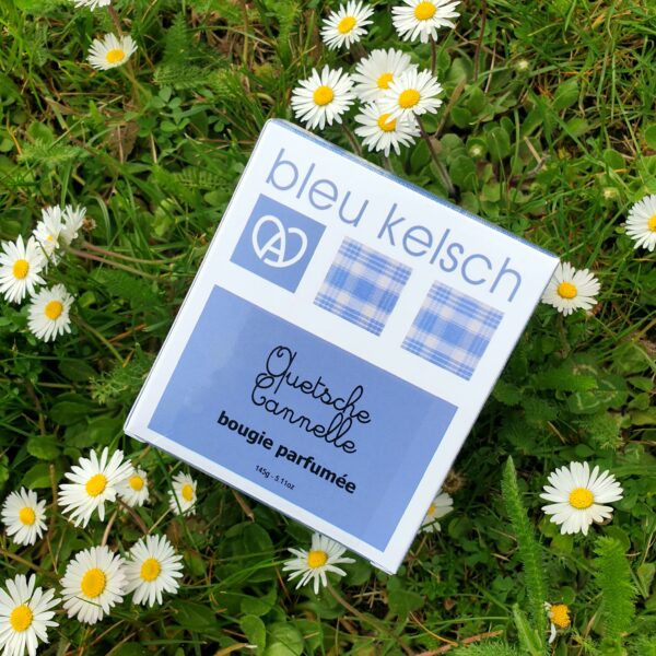 boite de bougie bleu kelsch au milieu des pâquerettes